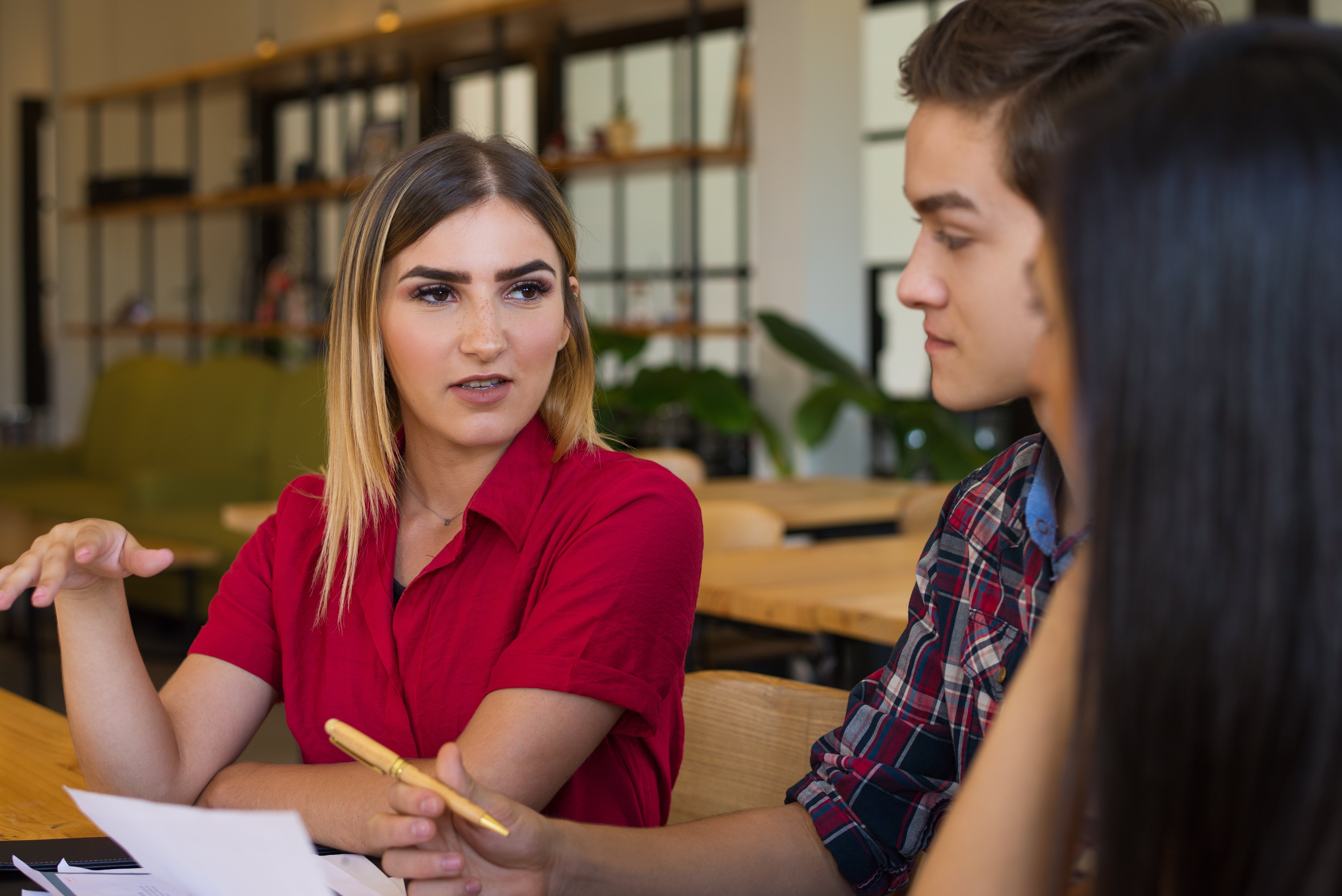 portrait-confident-young-woman-talking-her-friends-cafe